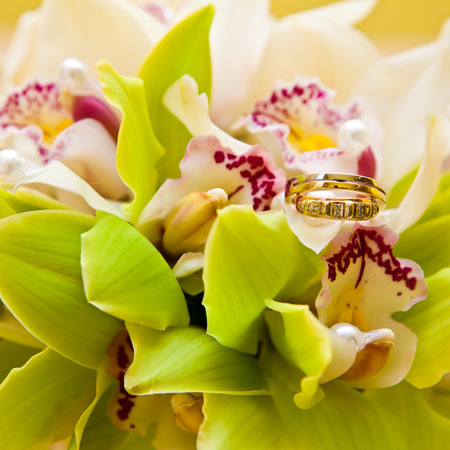 Wedding rings on a bouquet of orchidsの写真素材