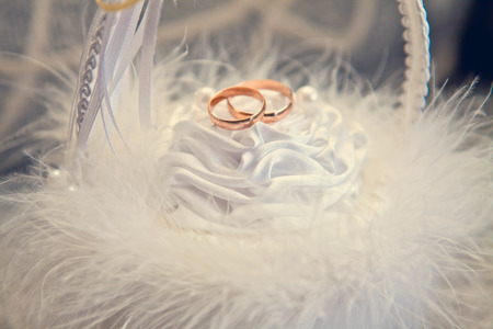 Wedding rings in a white fluffy basketの写真素材