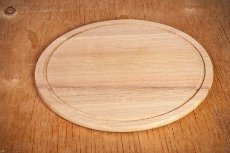 round cutting board on a wooden backgroundの写真素材