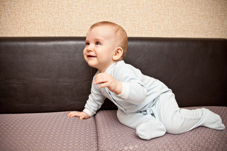 child in a blue suit sitting on a sofaの写真素材