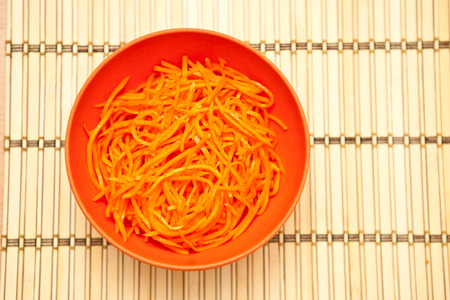 Korean carrots in a bowl on a wooden backgroundの写真素材
