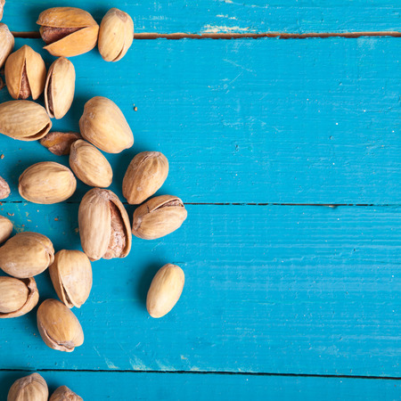 salted pistachios on a blue wooden table