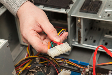 Technician holding a cable from the power supply.の写真素材