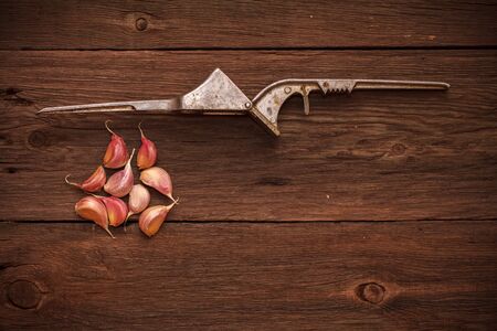 masher for garlic and garlic on a wooden backgroundの写真素材