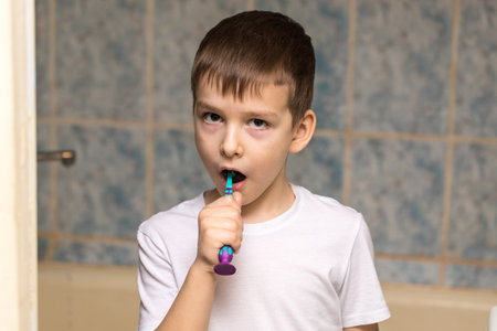 a boy of six is brushing his teeth in the bathroom. close-up portraitの写真素材