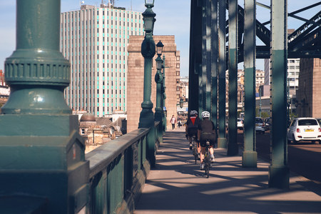 NEWCASTLE UPON TYNE, ENGLAND, UK - AUGUST 13, 2015: Cyclists crossing the Tyne Bridge over the River Tyne at Newcastle.のeditorial素材