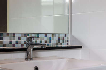 Close-up small basin and mirror in small bathroom, On Mosaic wall.の写真素材