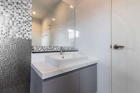 Close-up small basin and mirror in small bathroom, On Mosaic wall.の写真素材