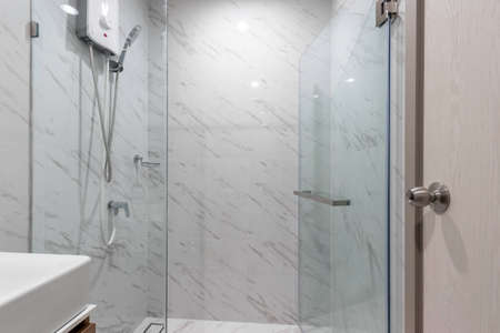 White Small Bathroom in Apartment with Water Heater and Shower Cabinの写真素材