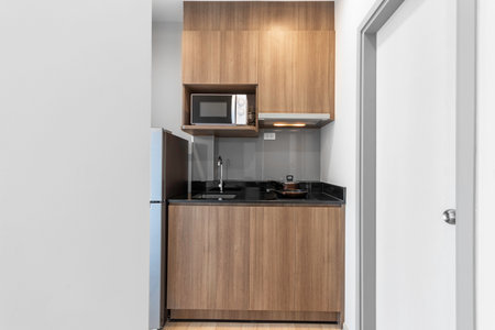 Wood Kitchen with Microwave and Electric Stove in Apartmentの写真素材