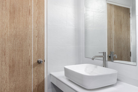 Close-up small basin and mirror in small bathroom, On white ceramic wall.の写真素材