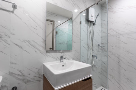White Modern Bathroom with Shower Cabin Glass and Big mirror in Apartmentの写真素材