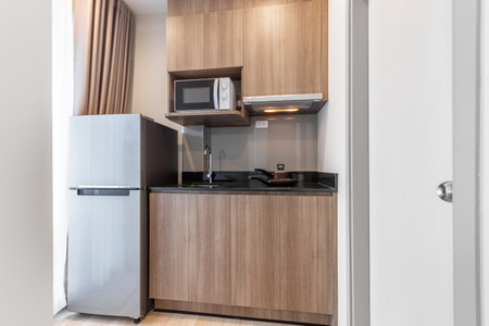 Small Wood Kitchen with Microwave and Electric Stove in Apartmentの写真素材