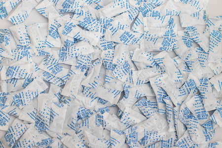 Desiccant silica on the pack. Closeup view. packet of silica gel buried in silica crystals. There are words desiccant and do not eat on packetの写真素材