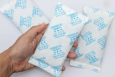 Desiccant silica on the pack. Closeup view. packet of silica gel buried in silica crystals, write in front that Do not eat in Chinese, Japanese and English.の写真素材