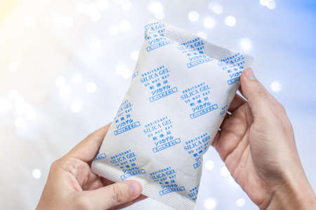 Desiccant Silica gel bag on hand with white light backgroundsの写真素材