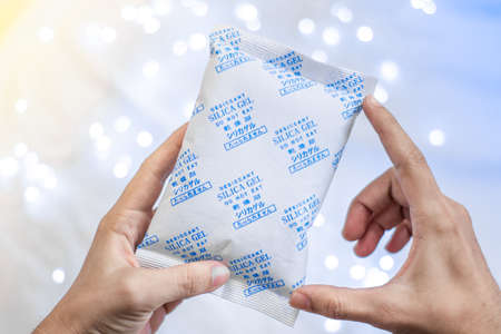 Desiccant Silica gel bag on hand with white light backgroundsの写真素材