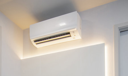 White air conditioner mounted on the wall inside the houseの写真素材