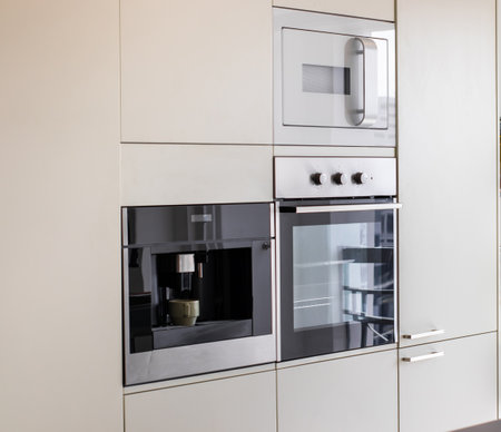 Microwave and oven built-in kitchen furniture in modern apartmentの写真素材