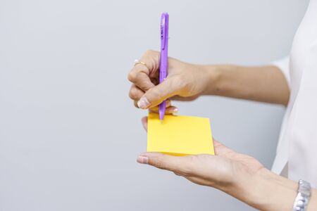 note with hand on white backgroundの写真素材