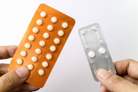 Oral contraceptive pills and Morning after pills in woman hands, Blisters of birth control pills....