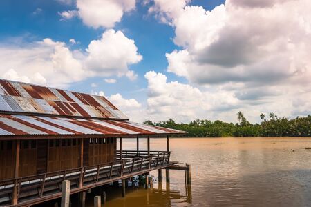 Wooden vintage style stilt house built above river Bangprakong, rural Thailand.の写真素材
