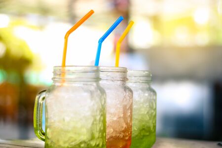 Colorful mason jar filled with ice with  blurred restaurant backgroundの写真素材
