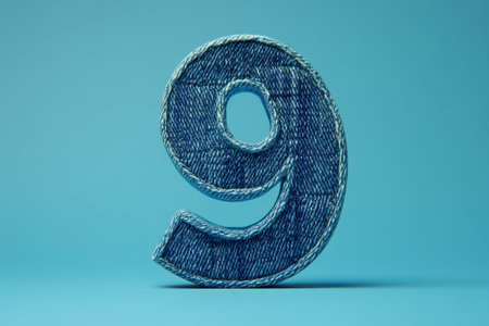 A blue denim number nine with a hole in the middle. The number nine is embroidered on a blue backgroundの素材