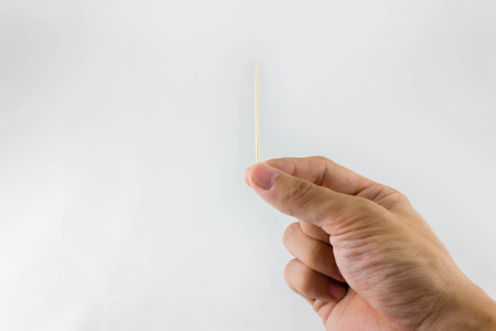 Hand holding a toothpickの写真素材