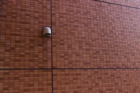 a single lamp on brick wall of old buildingの写真素材
