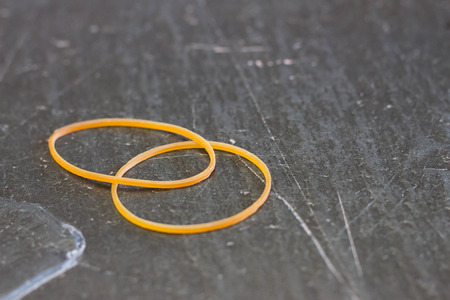 Two yellow rubber band on stone tableの写真素材
