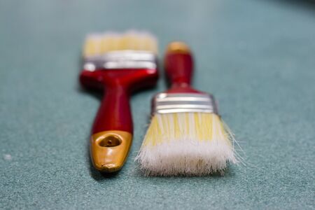Close up of two paint brush on green tableの写真素材