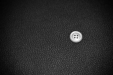A single white button on black leather wallet