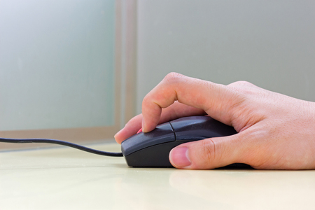 Hand using black mouseの写真素材