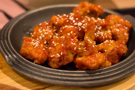 Spicy chicken on black plate, Korean food.の写真素材