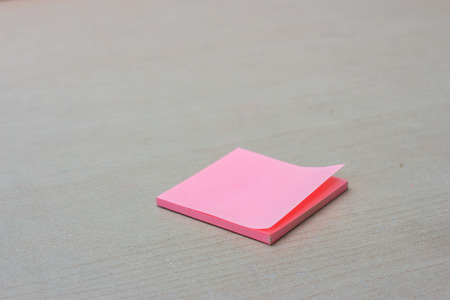 Pink post it on the wooden table