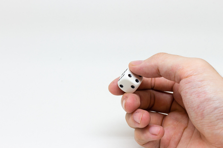 Hand holding dice on white backgroundの写真素材