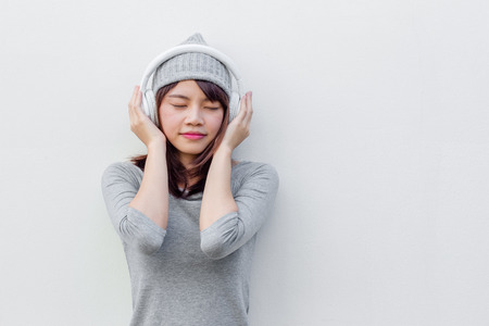 Asian woman listen to music with white headphoneの写真素材