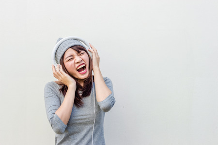 Asian woman listen to music with white headphoneの写真素材