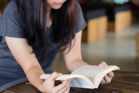 Woman with glasses reading a bookの写真素材