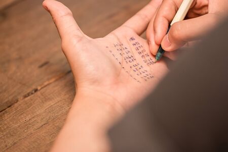 People cheating on test by writting answer on left hand