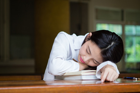 Asian woman taking a nap on the table during workの写真素材