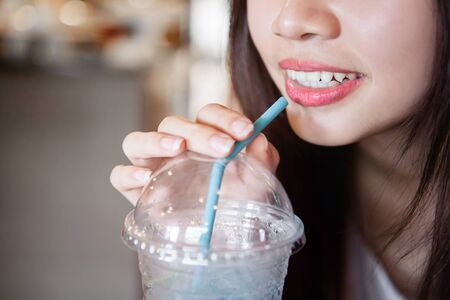 Close up of mouth drinking from straw with blurry backgroundの写真素材