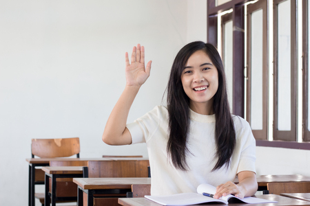 Asian woman raise hand in classroomの写真素材