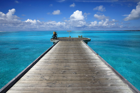 Wooden pier on the beach in the blue sea of Maldivesの写真素材