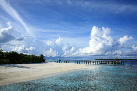 Wooden pier on the beach in the blue sky in Maldivesの写真素材