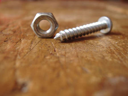 hex nut & screw on weathered piece of wood