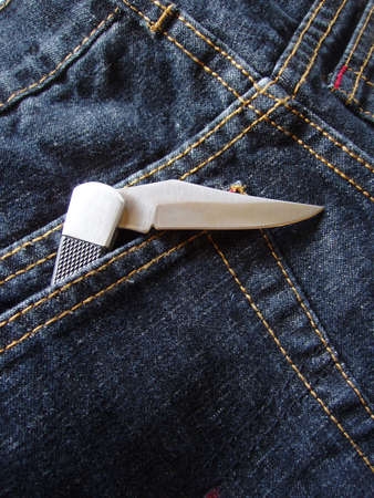 open pocket knife in back pocket of jeansの写真素材