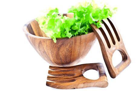green lettuce leaves in a wood salad bowl with two big wood forks on a white backgroundの写真素材