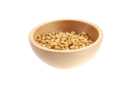 pine nuts in a wood bowl. white backgroundの写真素材